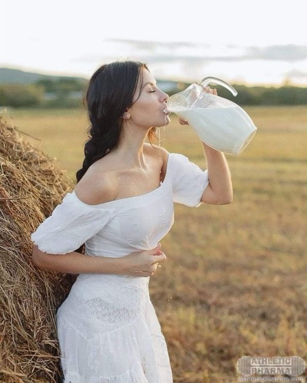 Красивая девушка пьет свежее молоко