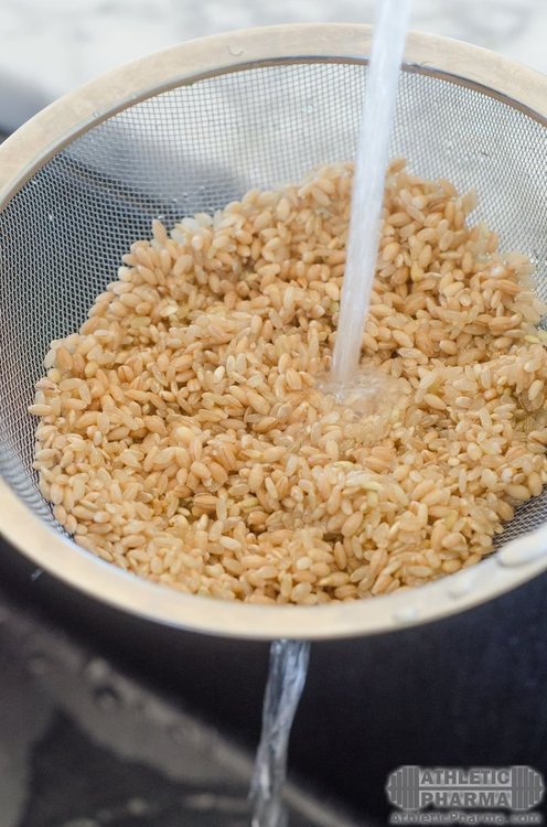 Промывает бурый рис под водой