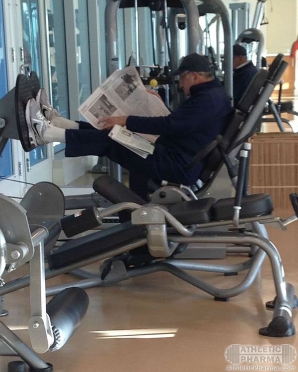 Дед читает газету в тренажерном зале